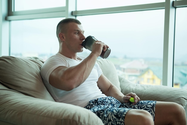 Junger mann trinkwasser aus der flasche