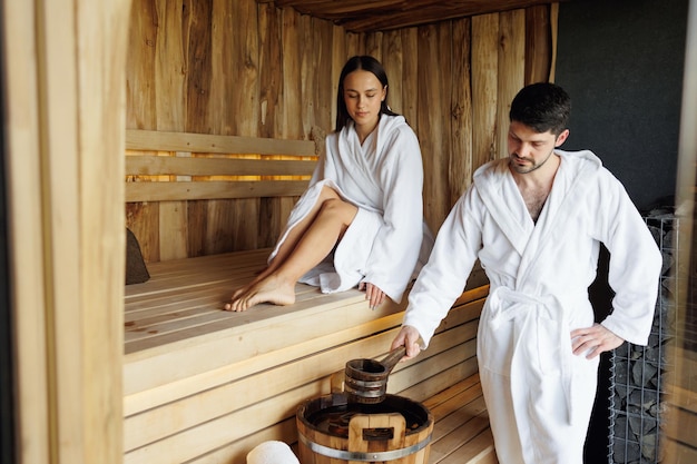 Junger Mann und Frau, die sich in der Sauna des Spa-Resorts entspannen