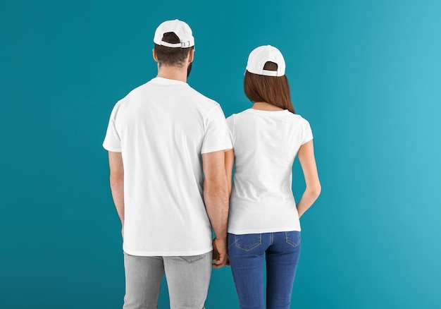 Junger Mann und Frau in stilvollen weißen T-Shirts auf farbigem Hintergrund Mockup für Design