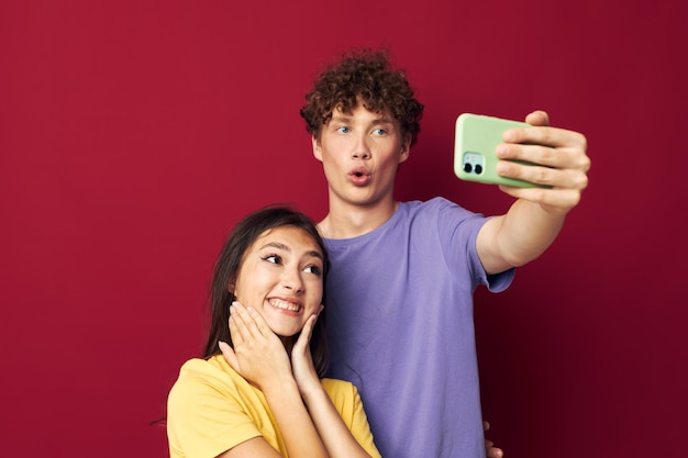 Junger Mann und Mädchen machen ein Selfie, das isolierten Hintergrund umarmt