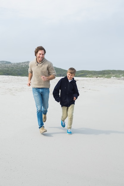 Junger Mann und Sohn, die am Strand rüttelt