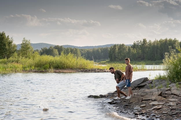 Junger Mann und Teenager genießen die Zeit am See