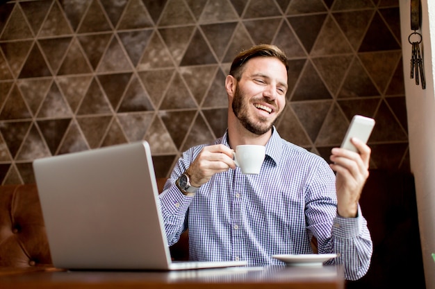 Junger Mann workin auf Laptop im Café