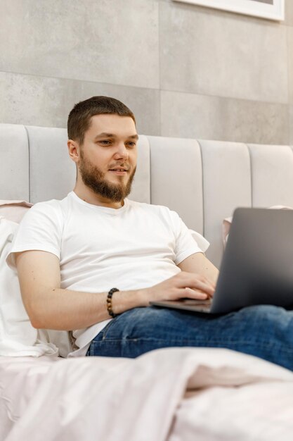 Junger Mann zu Hause auf Sofa mit Laptop