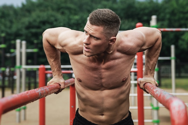 Junger muskulöser Mann während seines Trainings auf der Straße