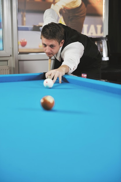 junger Profi-Billardspieler, der beim Billard- oder Snooker-Pool-Sportspiel die beste Lösung und den rechten Winkel findet