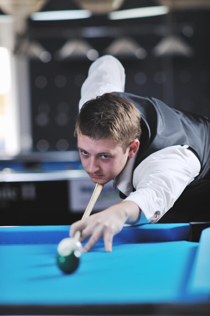 junger Profi-Billardspieler, der beim Billard- oder Snooker-Pool-Sportspiel die beste Lösung und den rechten Winkel findet