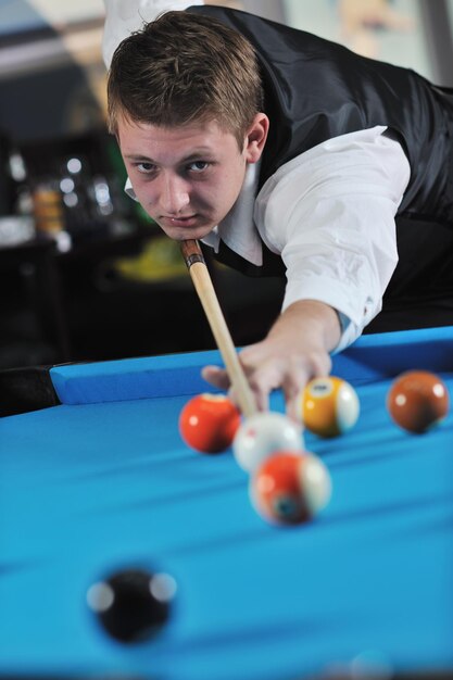 junger Profi-Billardspieler, der beim Billard- oder Snooker-Pool-Sportspiel die beste Lösung und den rechten Winkel findet