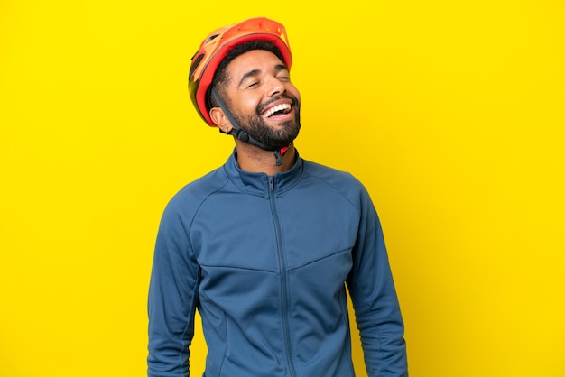 Junger Radfahrer Brasilianer isoliert auf gelbem Hintergrund lachend
