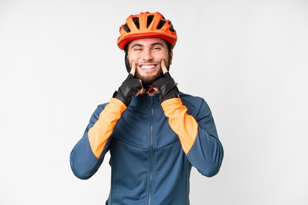 Junger Radfahrer mit isoliertem weißem Hintergrund, der mit einem glücklichen und angenehmen Gesichtsausdruck lächelt