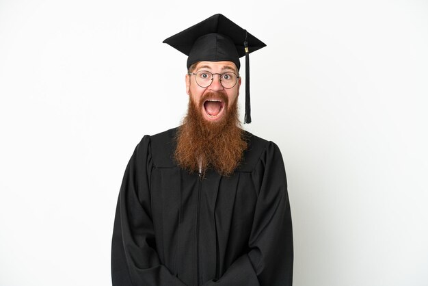 Junger rötlicher Mann mit Universitätsabschluss isoliert auf weißem Hintergrund mit überraschtem Gesichtsausdruck