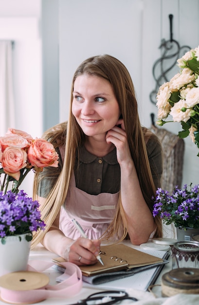 Junger schöner Florist in einem Blumenladen