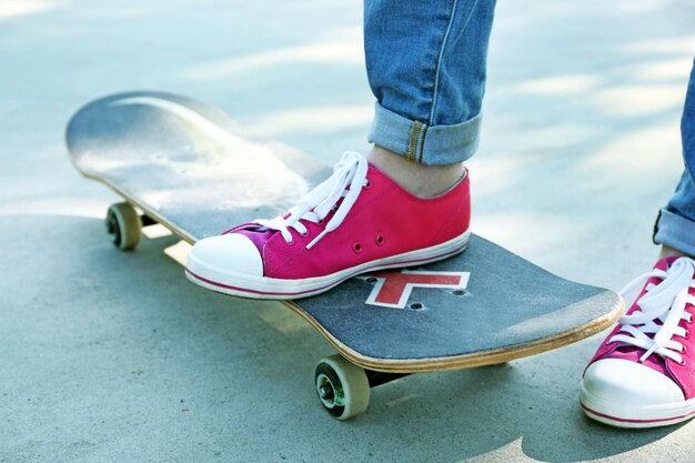 Junger Skateboarder in Gummischuhen, der auf Skate steht