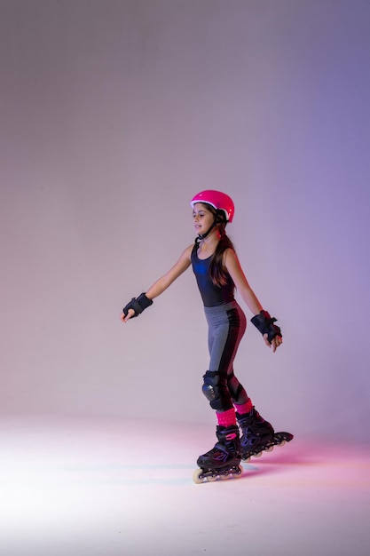 junger Skater-Athlet mit rosa Helm und Schutzausrüstung für Wettbewerbsstudiofoto