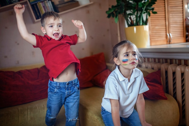 Junger Sportfan schaut sich Sportspiele an und jubelt ihrem Team zu Hause im Fernsehen zu