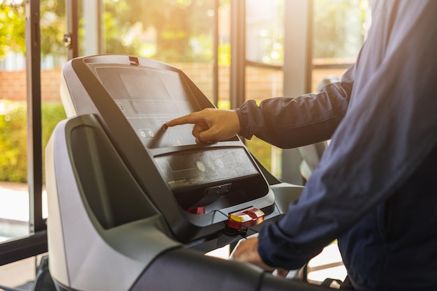 Junger Sportler, der auf dem Laufband läuft. Close up männlichen Läufer trainieren Indoor-Fitnessstudio. Fitness-Mann Joggen in Sportbekleidung. Trainieren und gesund