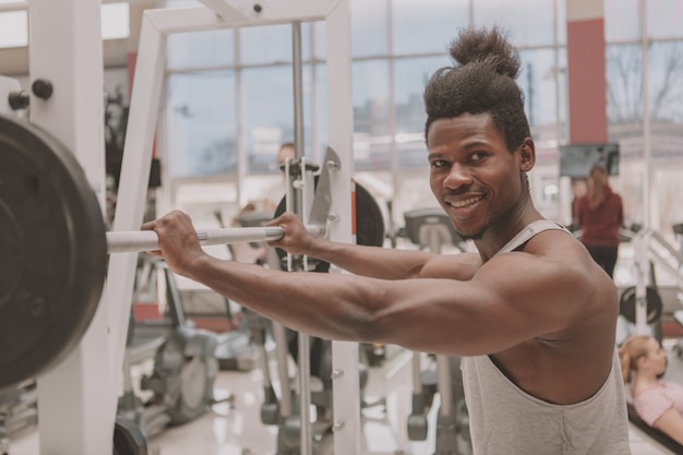 Junger Sportler, der mit Barbell ausarbeitet