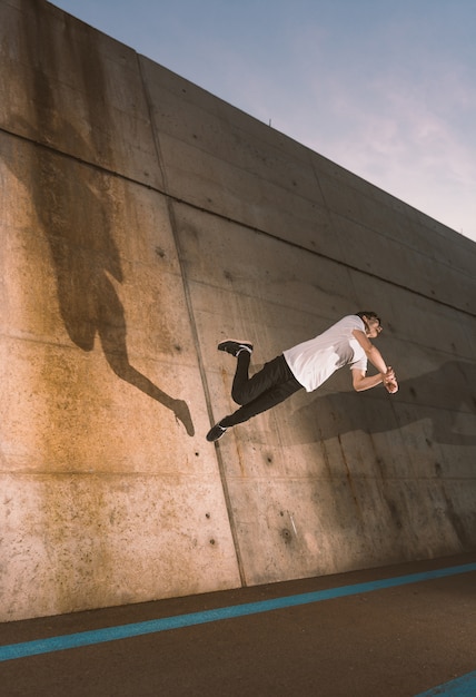 Junger Sportler, der Parkour übt.