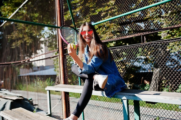 Junger sportlicher Mädchenspieler mit Tennisschläger auf Tennisplatz.