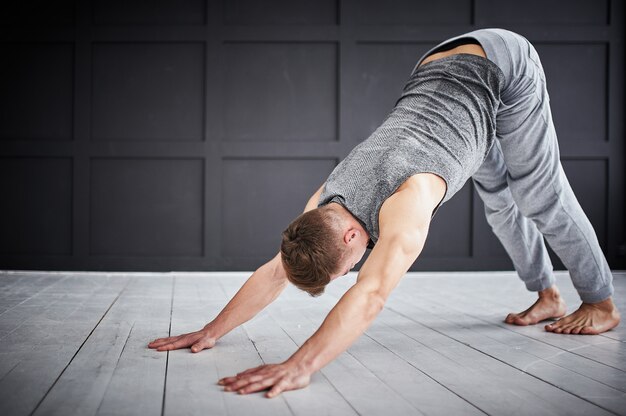 Junger starker Mann praktiziert Yoga im Yoga-Studio