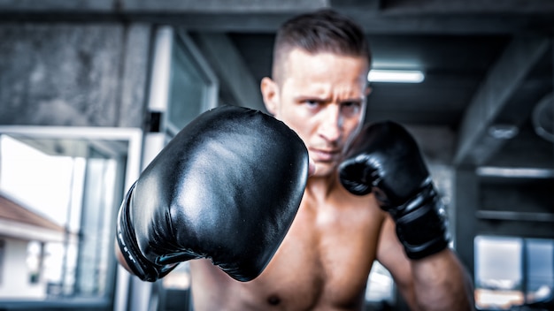 junger starker Sportmannboxer machen Übungen im Fitnessstudio