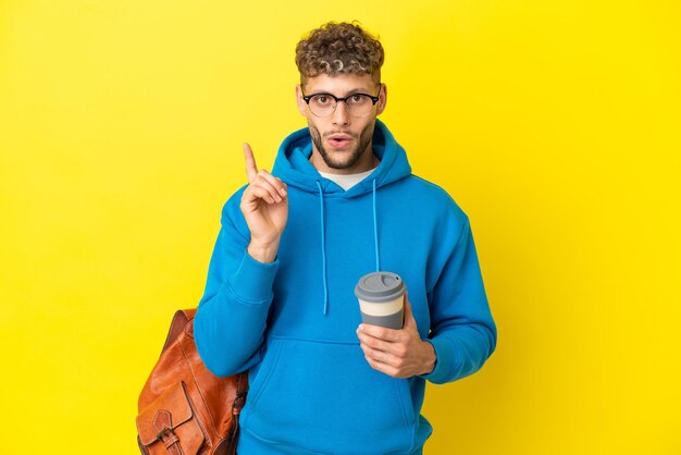 Junger Student, blonder Mann, isoliert auf gelbem Hintergrund, der beabsichtigt, die Lösung zu realisieren, während er einen Finger hochhebt