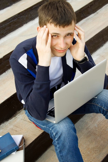 Junger Student, der an einem Laptop arbeitet