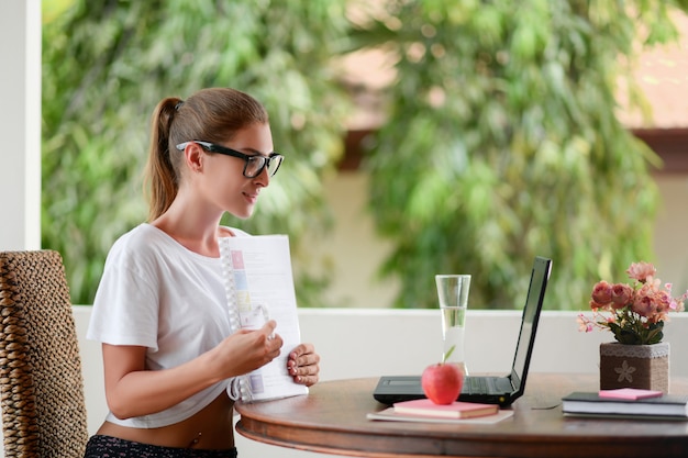 Junger Student, der an einem Tisch mit einem Laptop sitzt