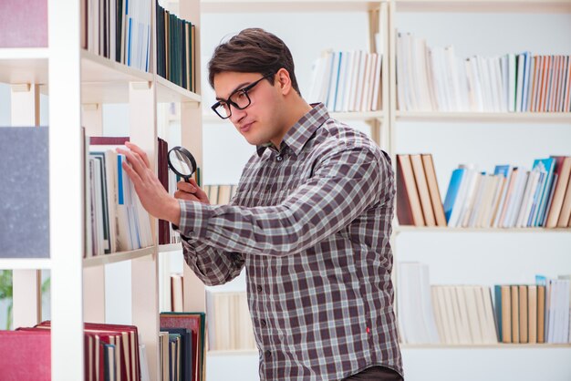 Junger Student, der nach Büchern in der Collegebibliothek sucht