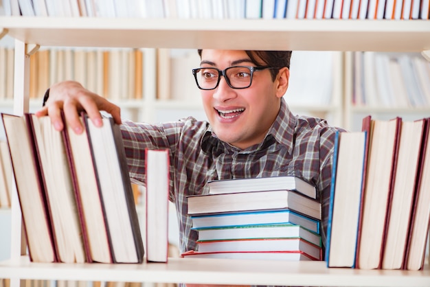 Junger Student, der nach Büchern in der Collegebibliothek sucht