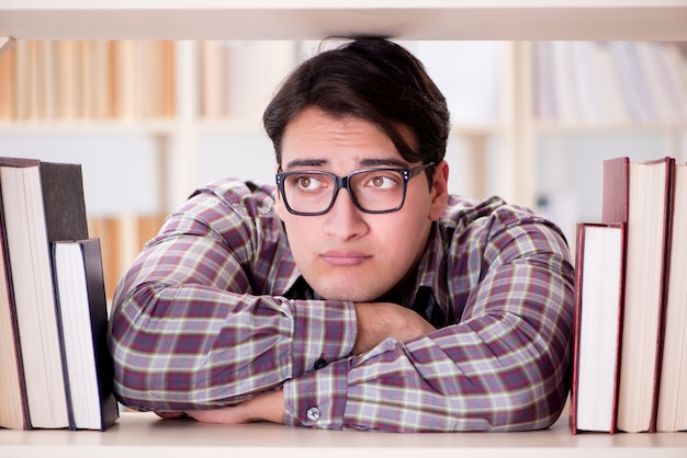 Junger Student, der nach Büchern in der Collegebibliothek sucht