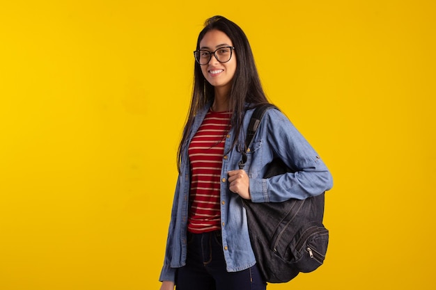 Junger Student, der Rucksack und Bücher im Studiofoto hält