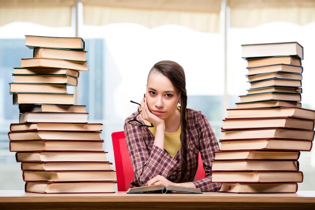 Junger Student mit Stapel Büchern