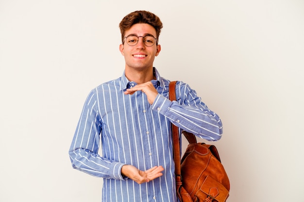 Junger Studentenmann auf Weiß, der etwas mit beiden Händen, Produktpräsentation hält.