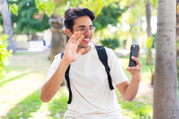 Junger studentischer Mann im Freien mit Handy