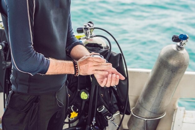 Foto junger taucher, der einen unterwasserkompass zum tauchen vorbereitet