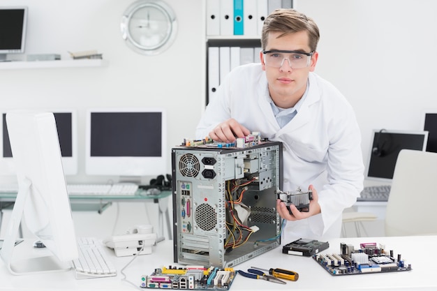 Foto junger techniker, der an defektem computer arbeitet