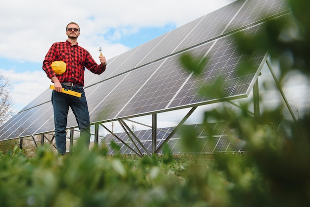 Junger Techniker, der Sonnenkollektoren auf Fabrikdach installiert