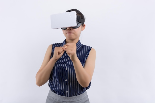 Junger Teenie-Gamer mit Augmented-Reality-Brille, der in Boxhaltung steht und Action-Simulator-Spiel mobile App-Spielerin spielt, die mit der Faust im virtuellen Training neuer Technologien mit VR-Headset kämpft