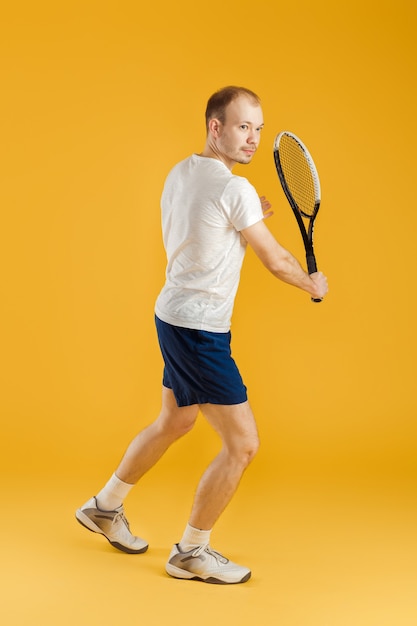 Junger Tennisspieler spielt Tennis auf einem Gelb