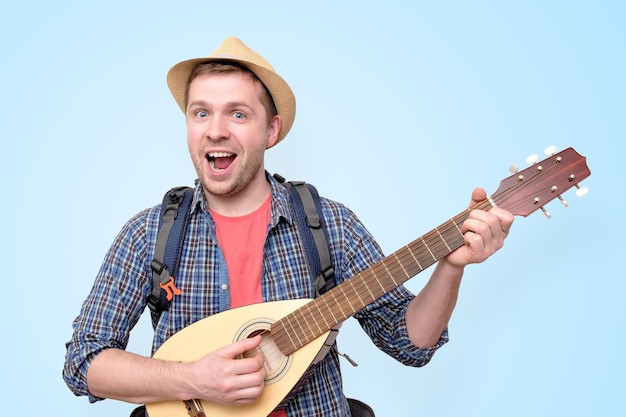 Junger Touristenmann, der Gitarre spielt und singt