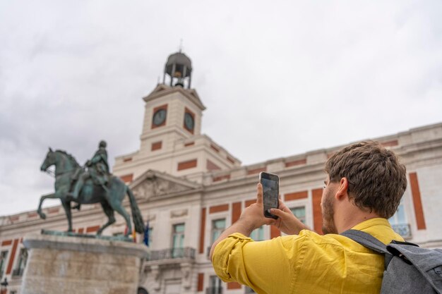 Junger Touristenmann mit Rucksack fotografiert in Madrid, Spanien