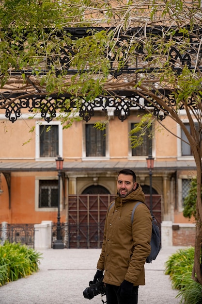 Junger, touristischer, attraktiver Mann mit Kamera in der Hand in Venedig