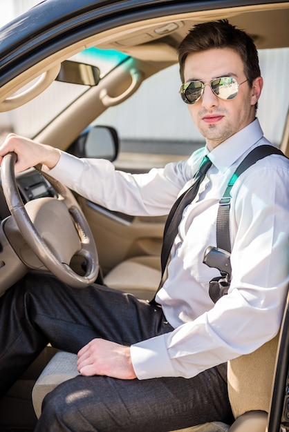 Junger überzeugter Geschäftsmann in der Sonnenbrille mit Gewehr.