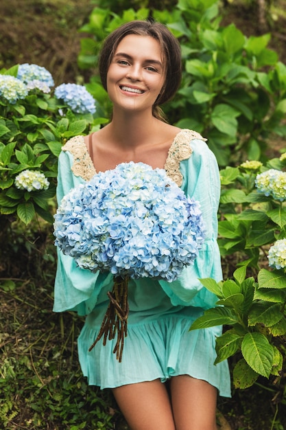 Junger und schöner Frauenflorist, der Hortensienblumen auf dem Feld sammelt