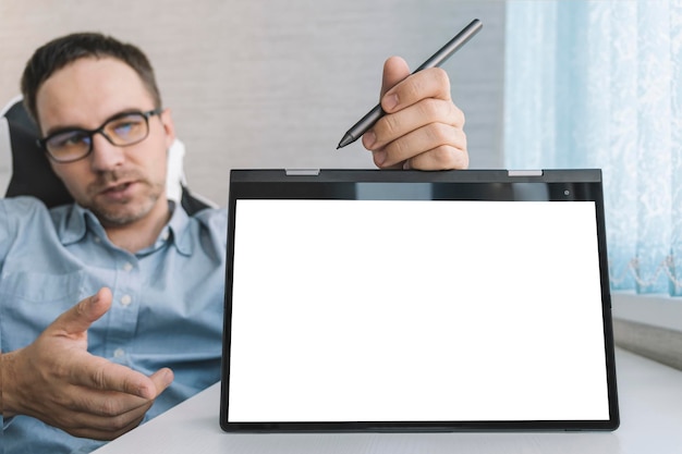 Junger Unternehmensberater, der Laptop mit leerem weißen Bildschirm hält Mock-up-Kopienplatz für Text Fernbildungskonzept