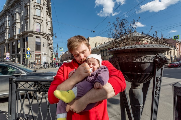 junger Vater, der versucht, mit seinem kleinen süßen Baby auf der Straße Schritt zu halten