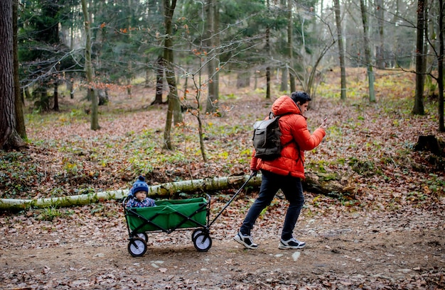 Junger Vater geht mit einem Kind in einem Lastwagen im Wald