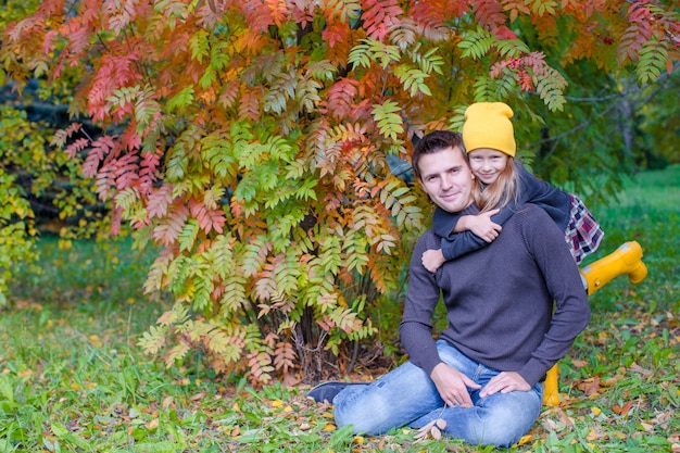 Junger Vater mit netter Tochter im Herbstpark draußen