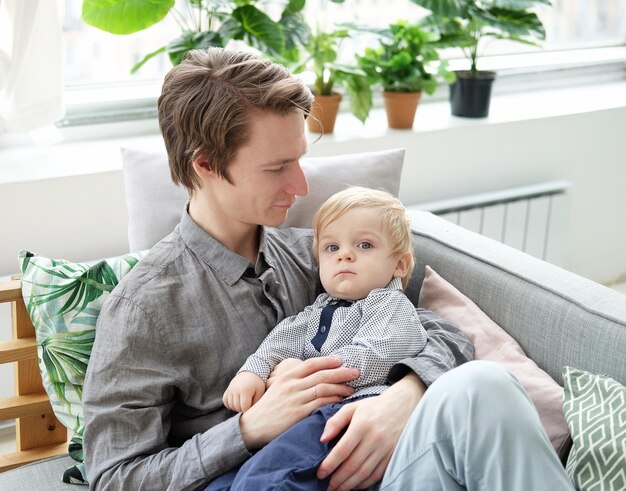 Junger vater mit seinem sohn zu hause haben eine tolle zeit zusammen glückliche zeit junge familie